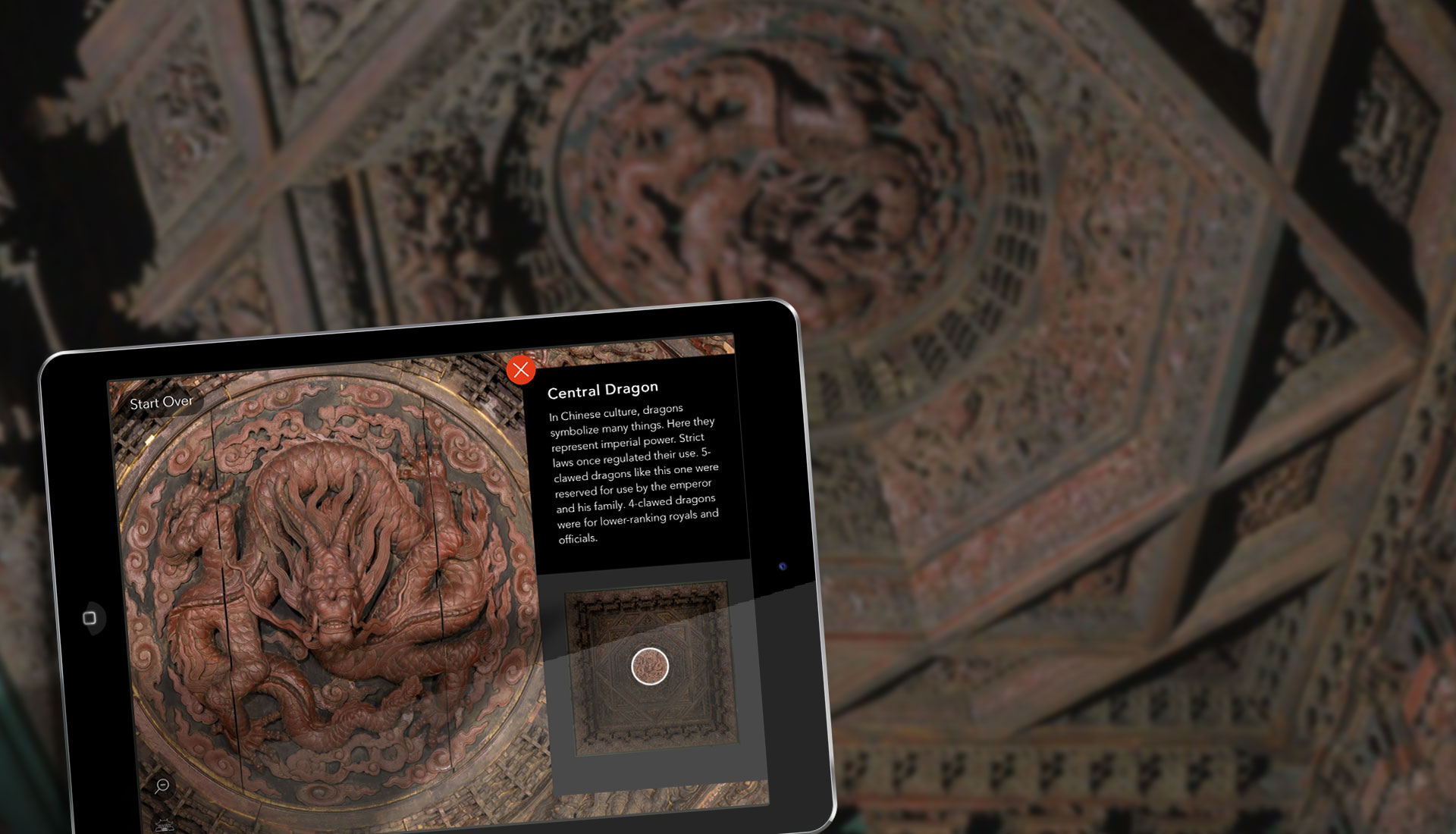 An iPad with the app on-screen, showing the large central dragon with complementary material to learn about this icon within the ceiling. 